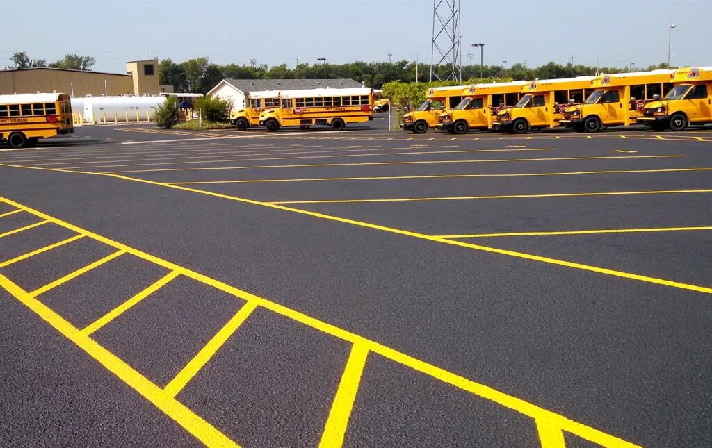 fresh sealcoat and pavement markings in a school bus parking lot