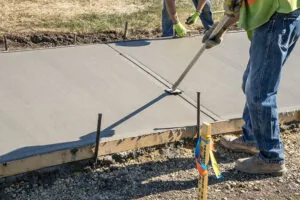 encore pavement employees working on a cement sidewalk