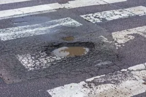 pothole in middle of pedestrian crossing in the road