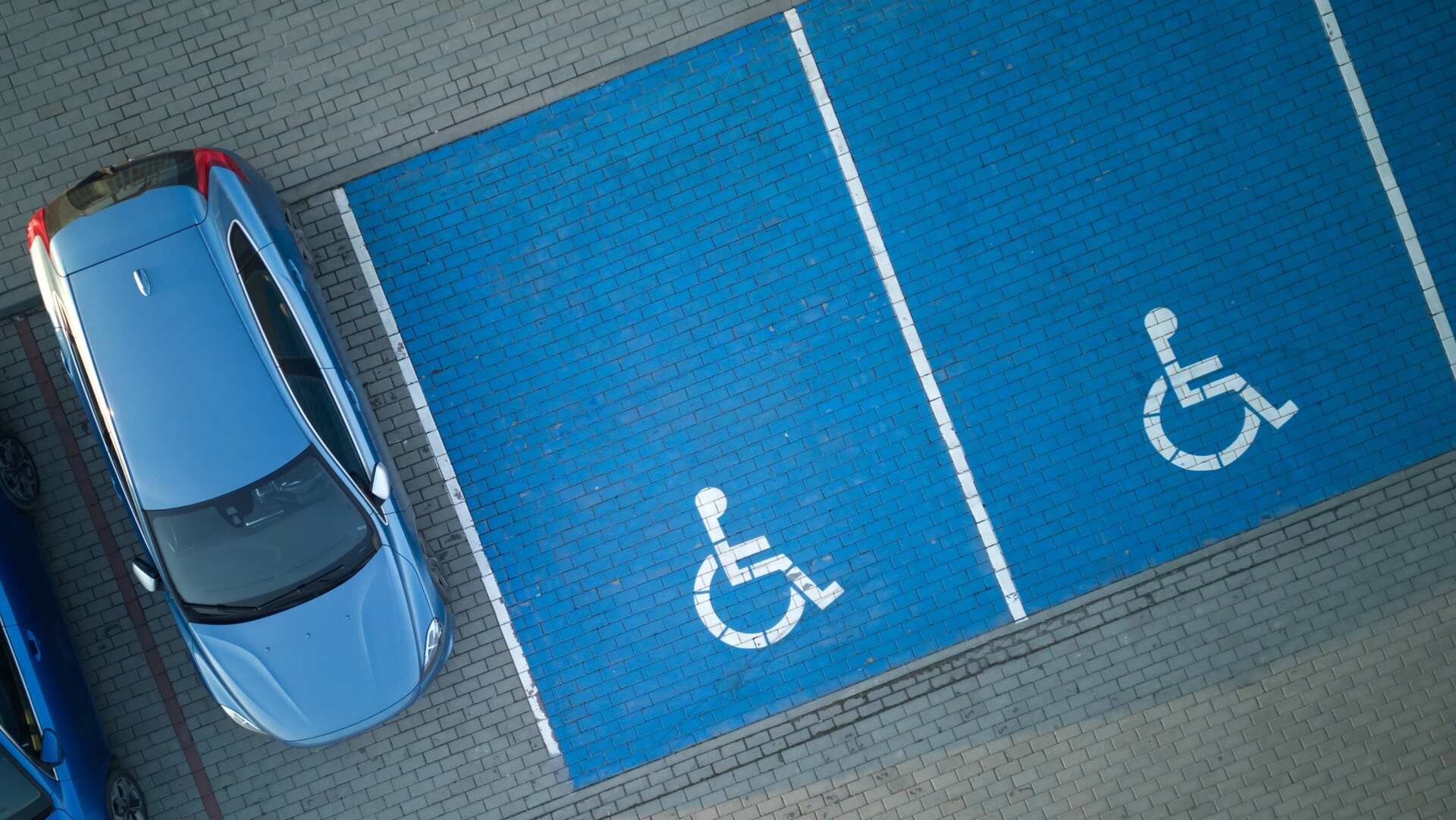 A blue car overhead, next to two ADA parking spaces.