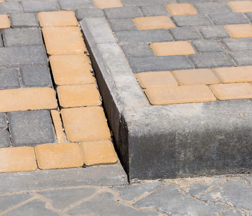 A close up of an ADA concrete ramp and a curb