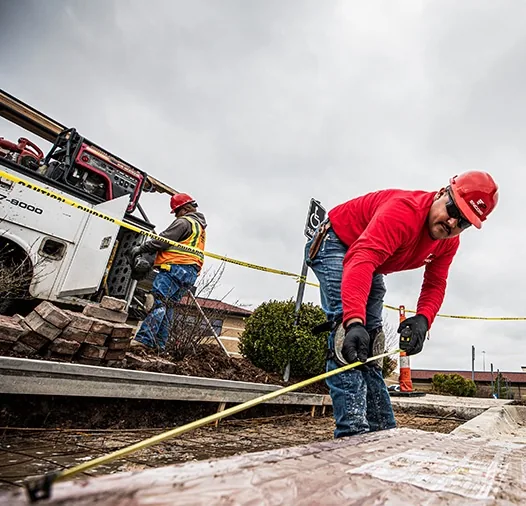 encore pavement employee measuring the ground