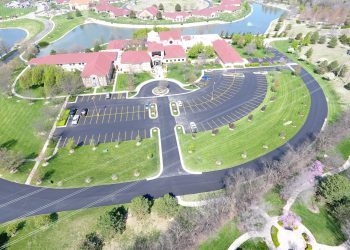 birdseye view of spiritual life center, parking lot, and a lake
