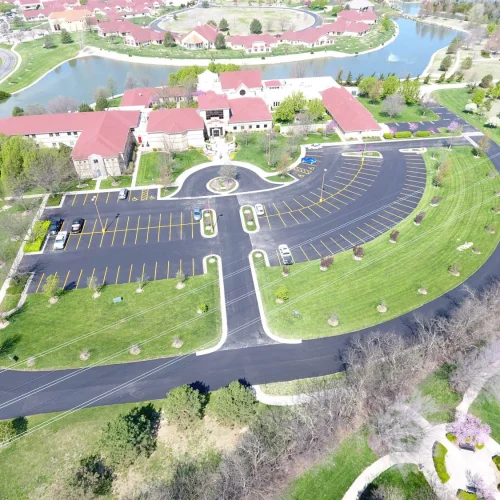 birdseye view of spiritual life center, parking lot, and a lake