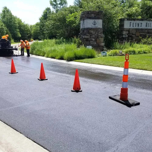 encore pavement employees working on a street with traffic cones