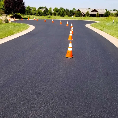 orange and white traffic cones in the middle of the road